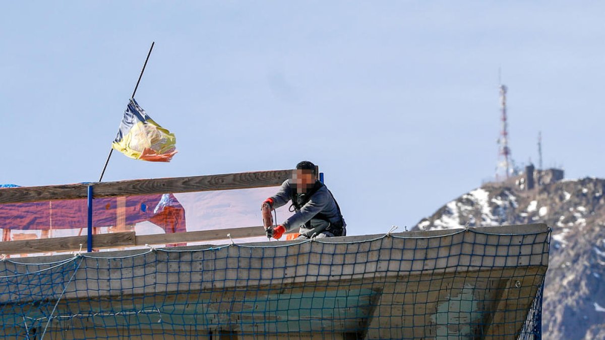Un obrer a dalt de la teulada en construcció.