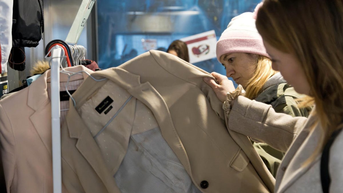 Clientes mirant la roba del mercat.