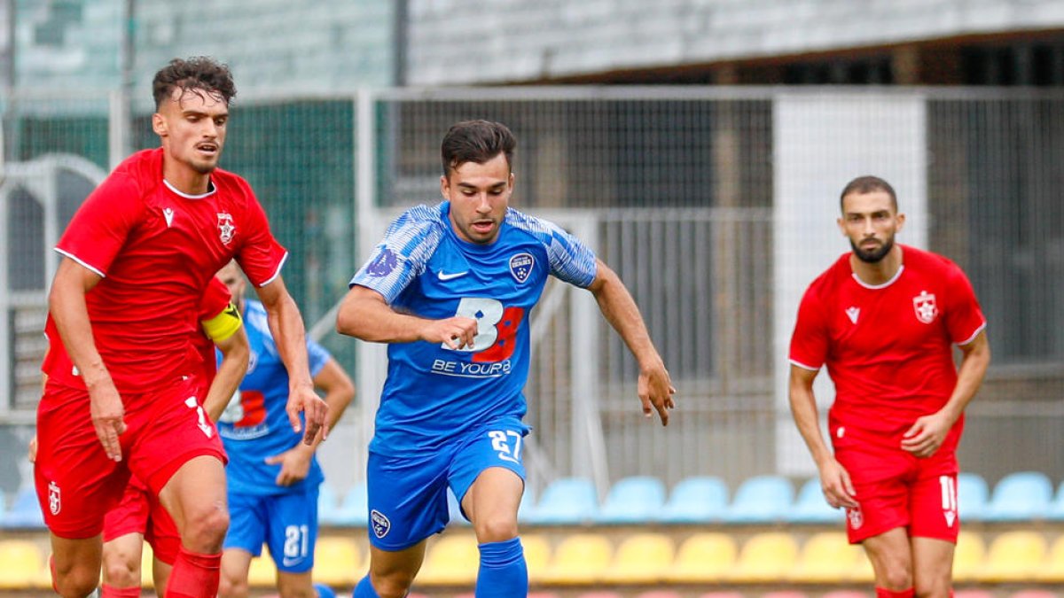 David López condueix la pilota davant l'oposició d'un jugador del Partizani.