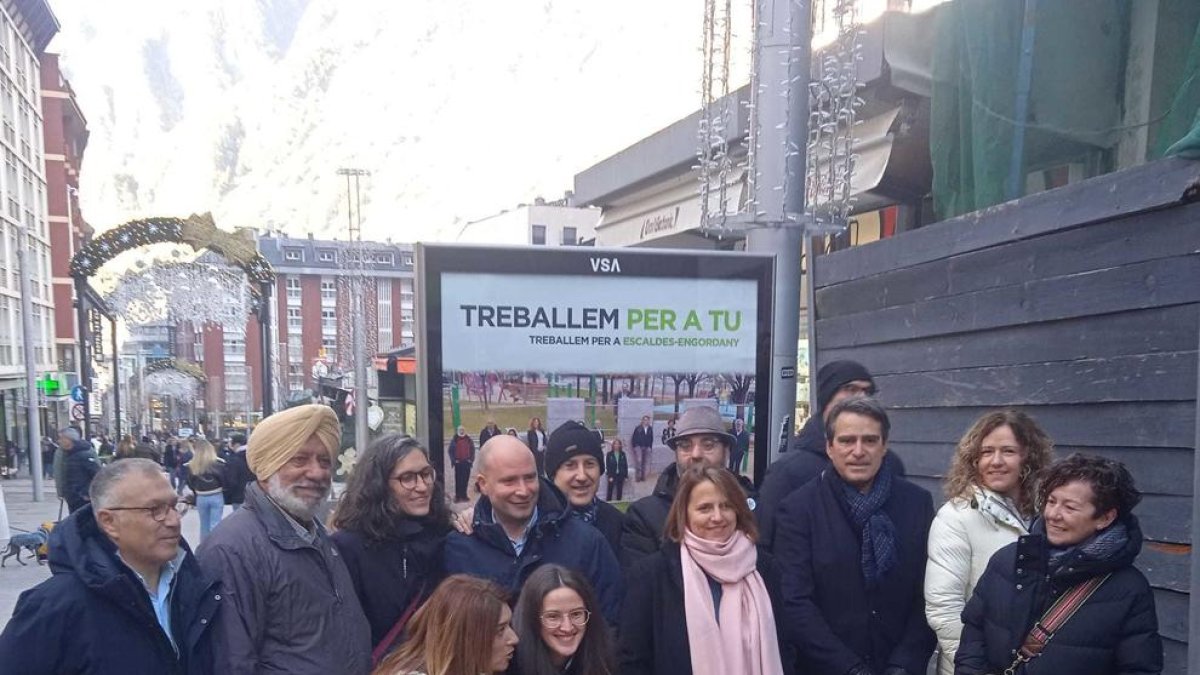 Els candidats de Consens en l'enganxada de cartells aquest migdia