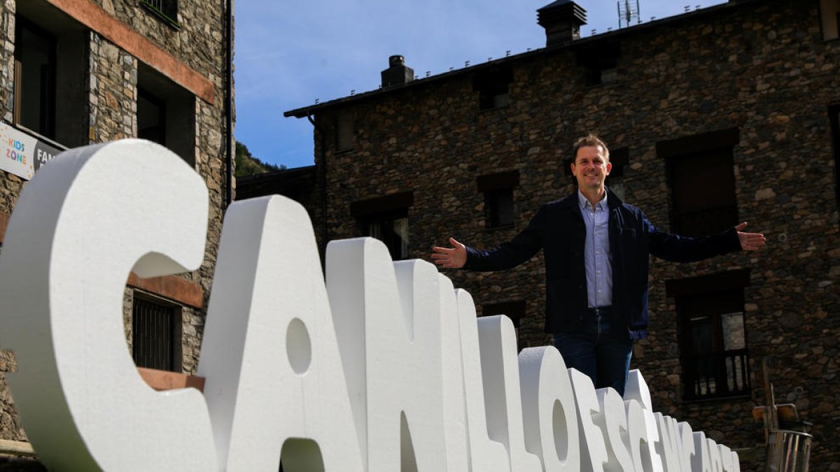 L'artista, Luke Jerram, davant el cartell del festival.