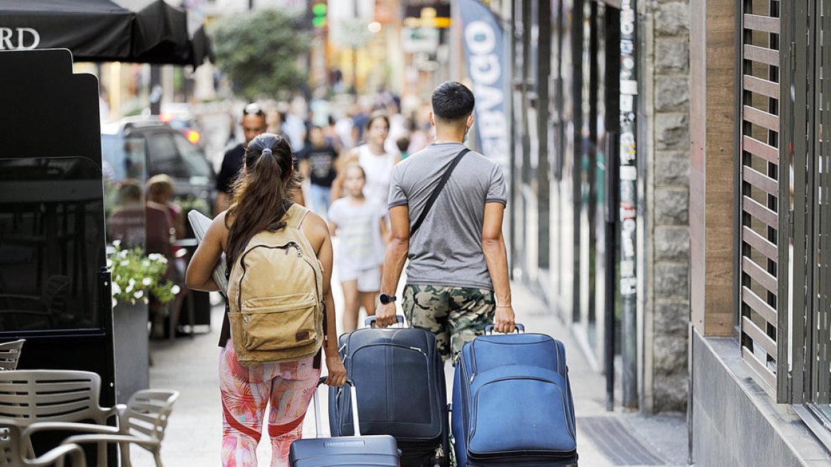 Dos turistes baixant l'avinguda Meritxell.