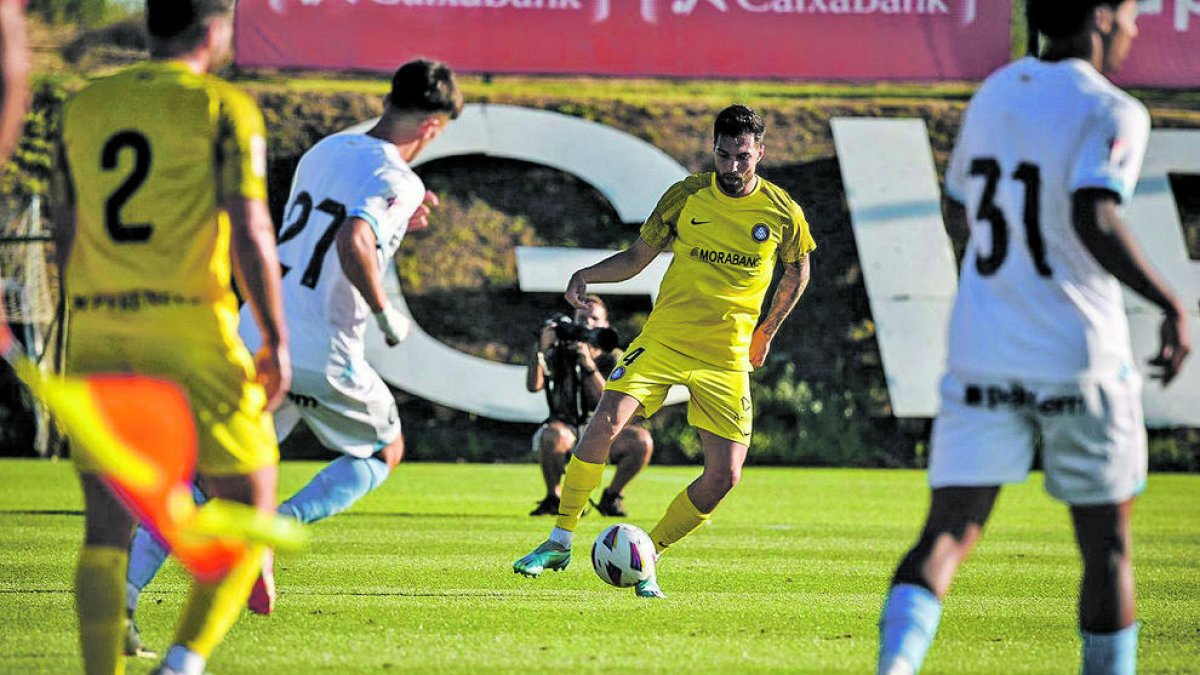Pastor controla una pilota davant de dos rivals gironins.