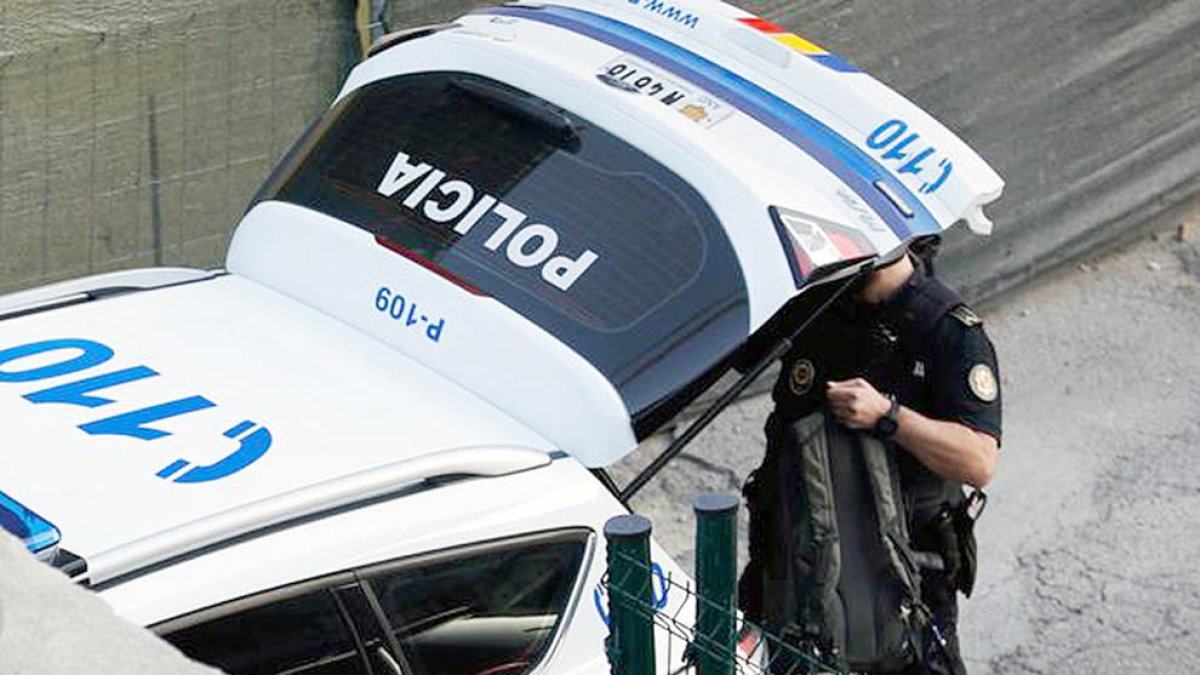 Un agent de policia davant del seu vehicle. ARXIU