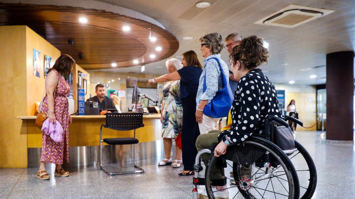 La ministra i diversos usuaris durant la presentació del servei exclusiu de tràmits.