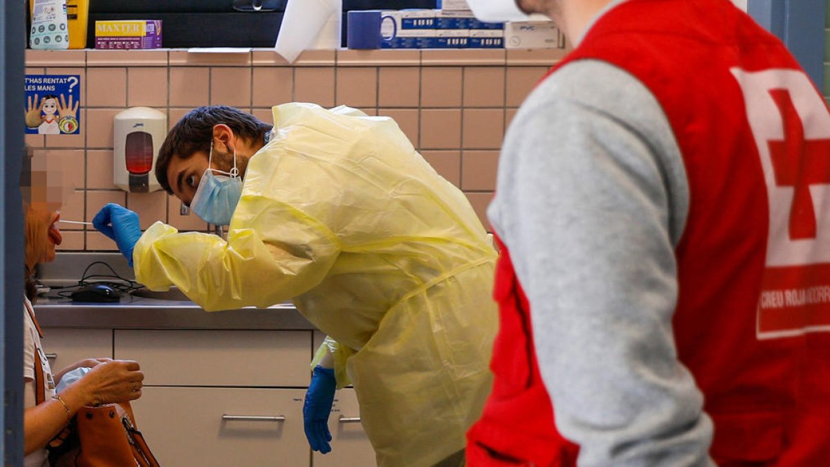 Un infermer fent la prova per detectar el virus.