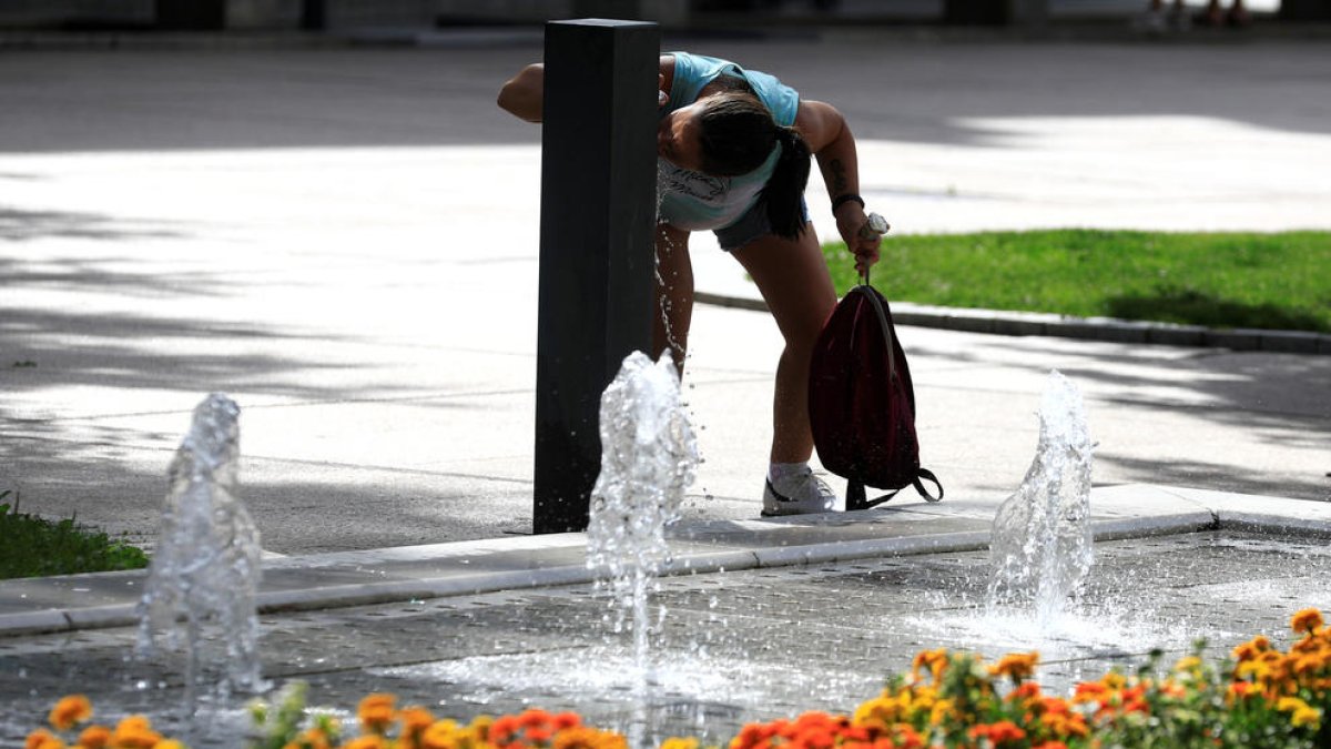 Una noia bevent aigua d'una font.