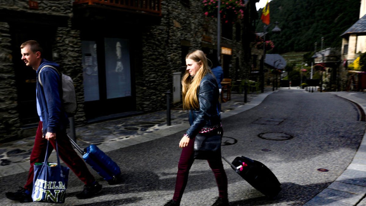Uns turistes abandonant un hotel de la parròquia.