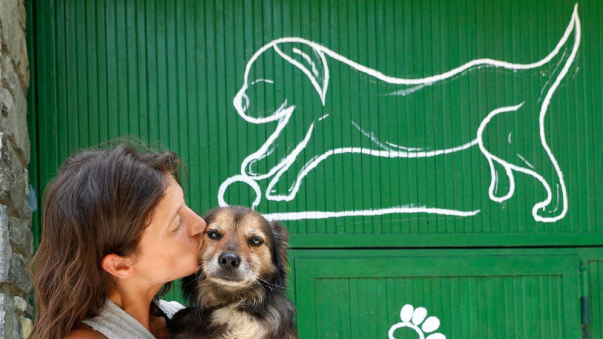 Una dona abraçant un gos.