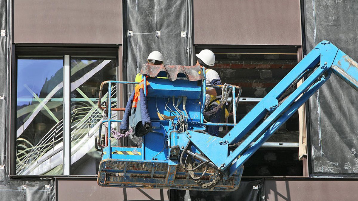 Treballadors en un edifici en construcció.