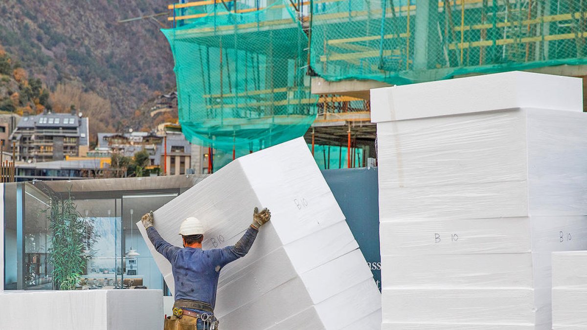 Un treballador amb material de construcció.