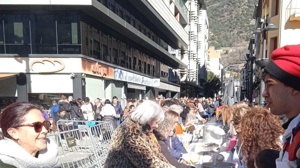 Veïns fent cua per recollir l'escudella.