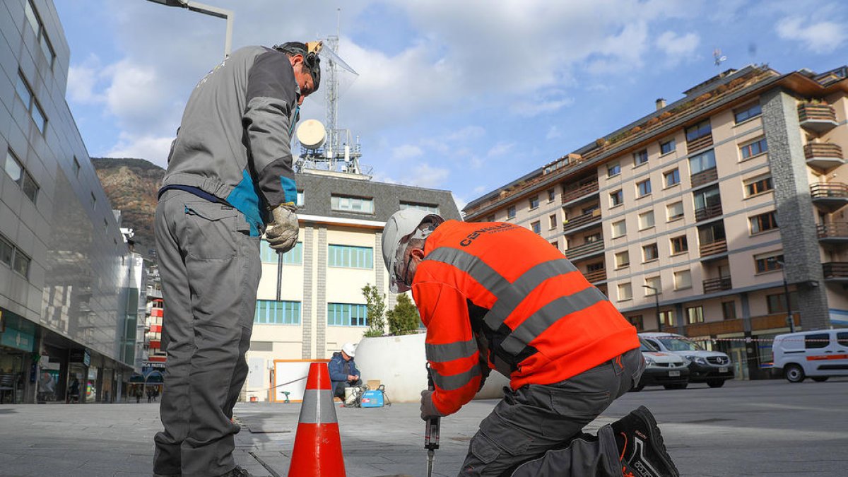 Dos obrers treballen a plaça de l'antiga caserna de bombers.