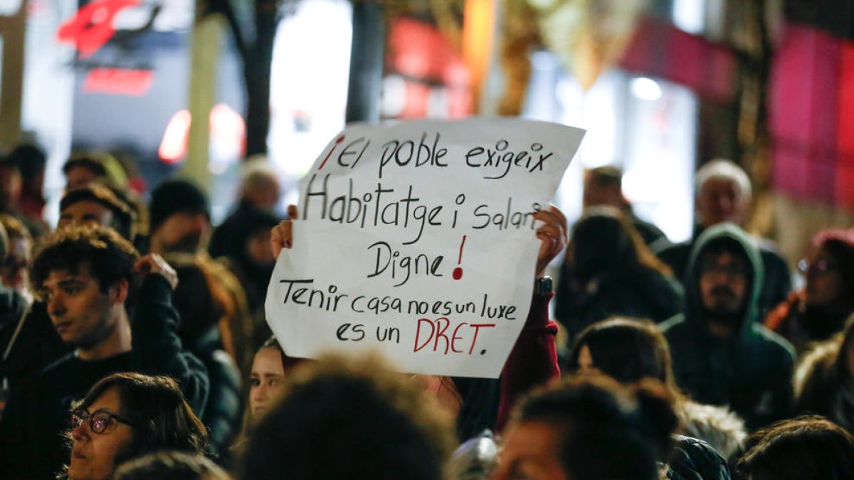 Un ciutadà aixecant un cartell reivindicatiu a una manifestació.