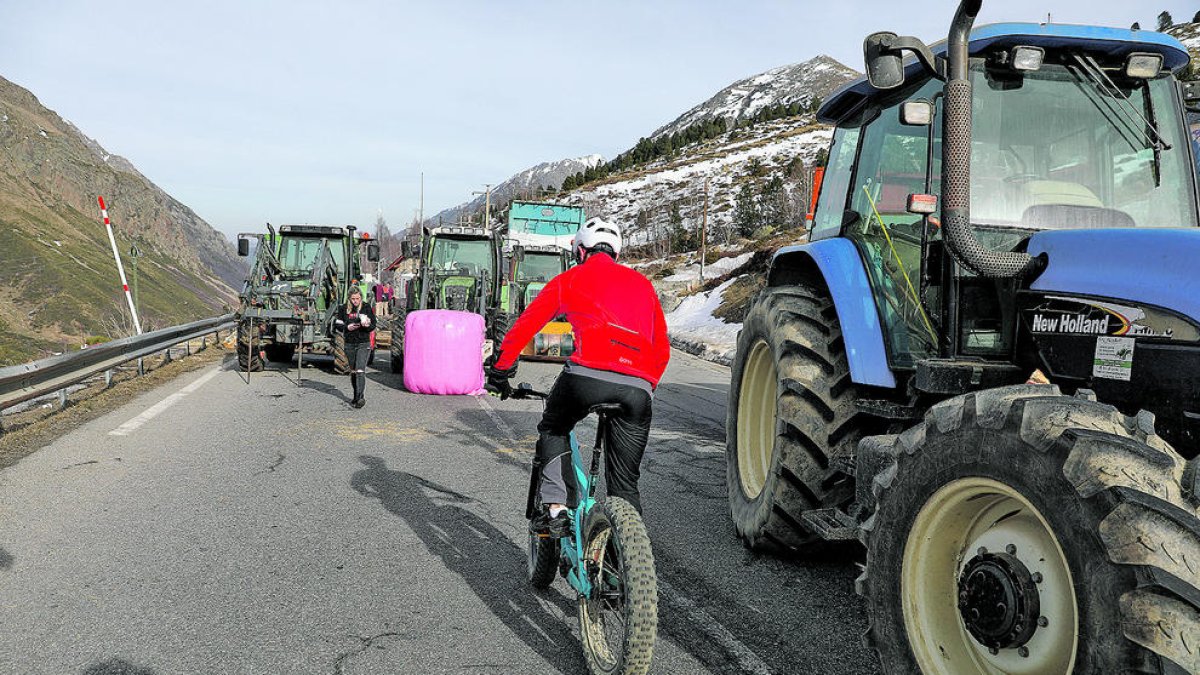 Un ciclista travessant el bloqueig dels agricultors.