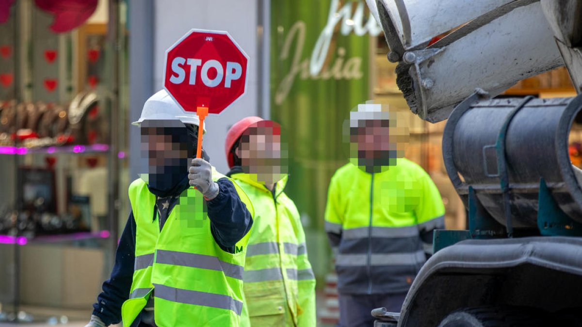 Tres operaris en una obra.