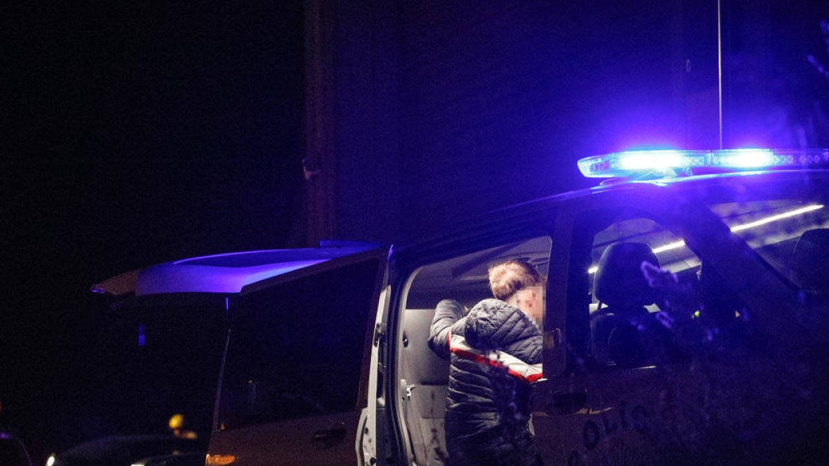 Un agent a punt de fer la prova d'alcoholèmia a un conductor.