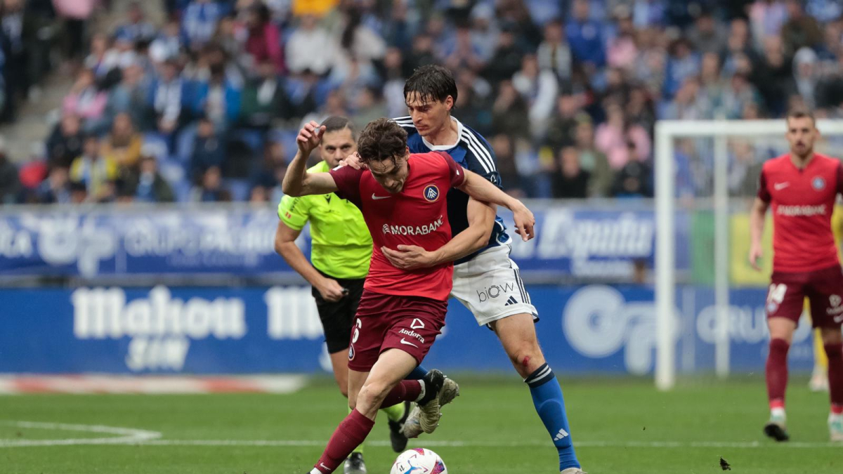 Jandro Orellana lluita per una pilota davant un jugador de l'Oviedo