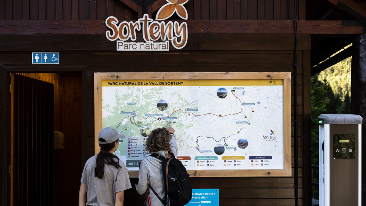 Dues excursionistes consulten el mapa de la vall de Sorteny.
