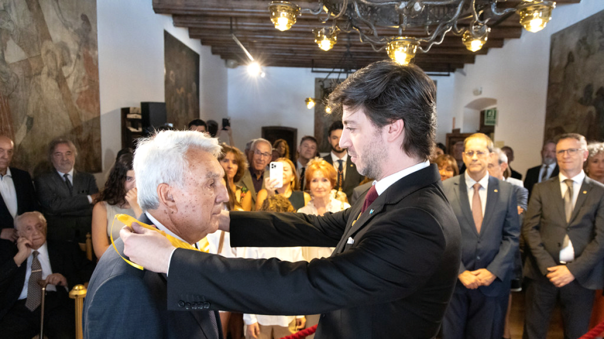 Ensenyat entrega la distinció a Cerqueda.