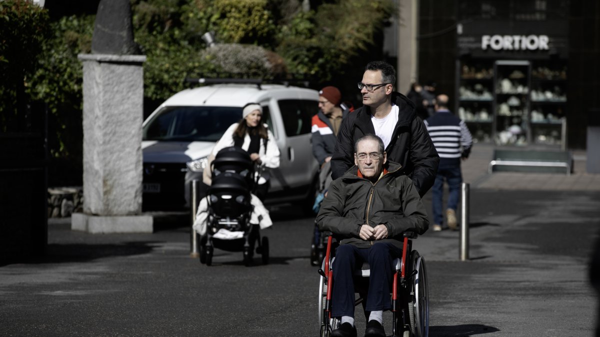 Una persona en cadira de rodes passejant per la capital.