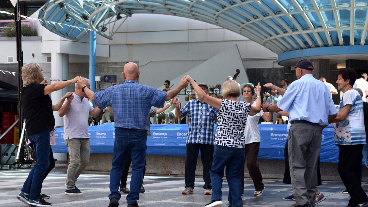 Un grup de persones ballant sardanes a la plaça dels Arínsols d'Encamp.