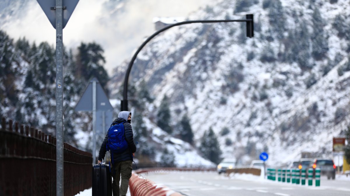 Un temporer transporta la maleta a la zona de la cascada de Moles.