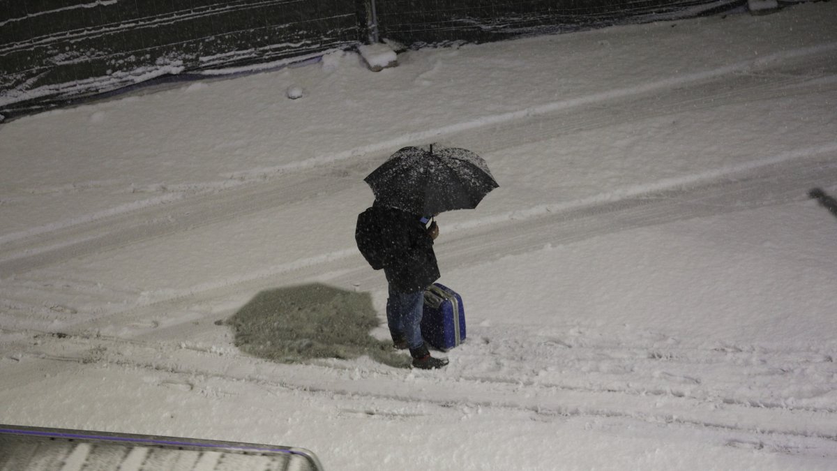 Un vianant protegint-se de la neu.