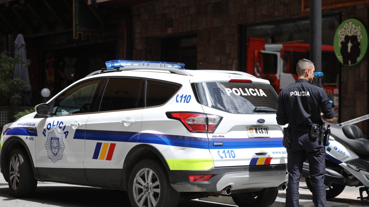 Un agent de la policia amb el vehicle patrulla