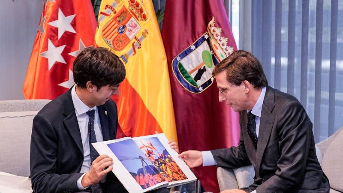 El cònsol major d'Andorra la Vella, Sergi González, mostran un llibre amb imatges d'andorra a l'alcalde de Madrid, José Luis Martínez-Almeida, en la trobada d'ahir