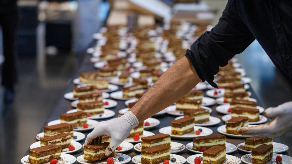 Un cuiner muntant postres per a un àpat.
