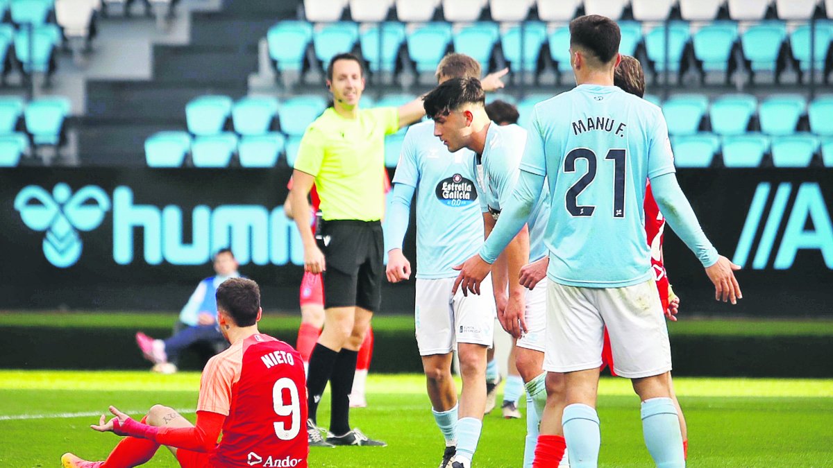 El davanter de l’FC Andorra, Manu Nieto, es lamenta d’una acció a la gespa i envoltat de rivals.