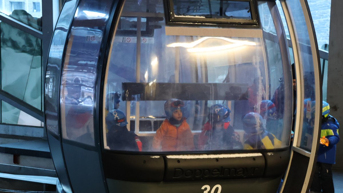 Alguns dels infants de l'escola de neu pujant al telecabina.