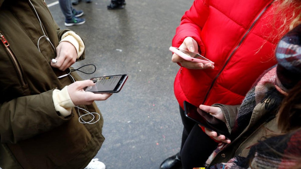 Adolescents utilitzant el mòbil.