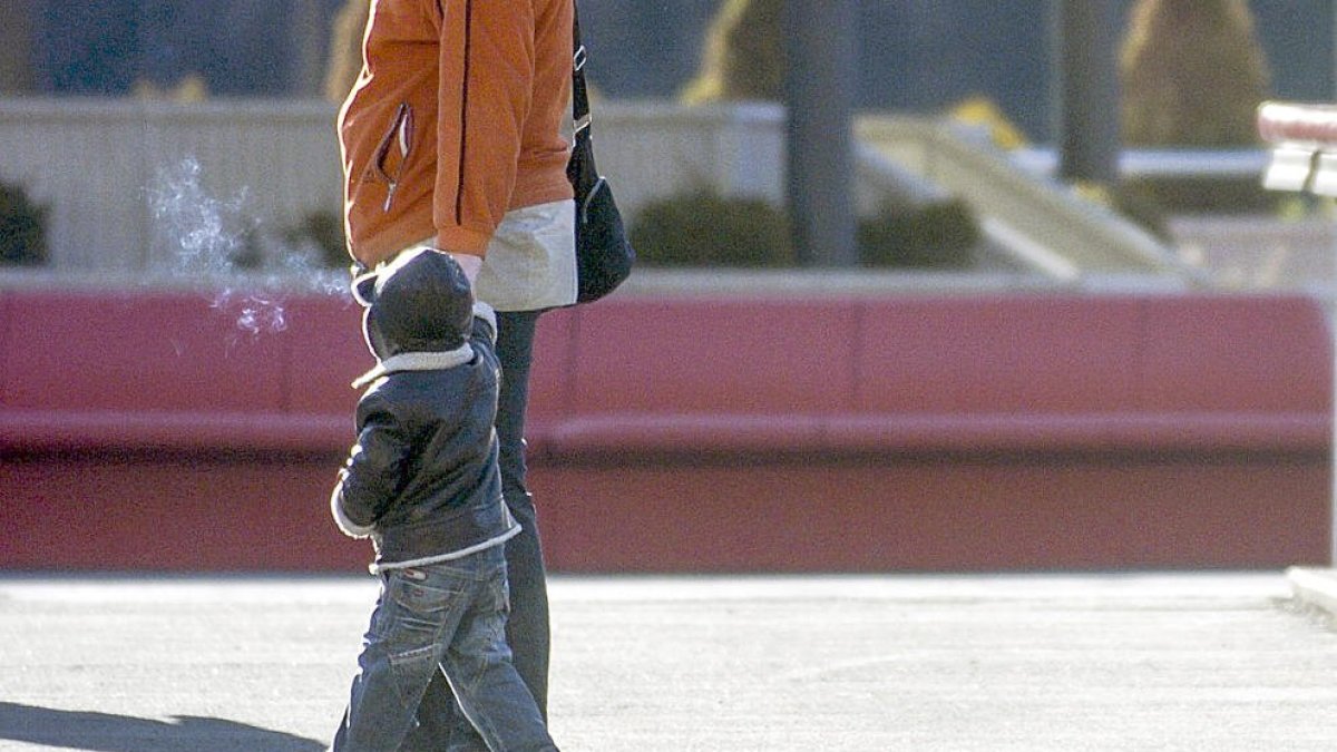 Un nen, de la mà de la seva progenitora.