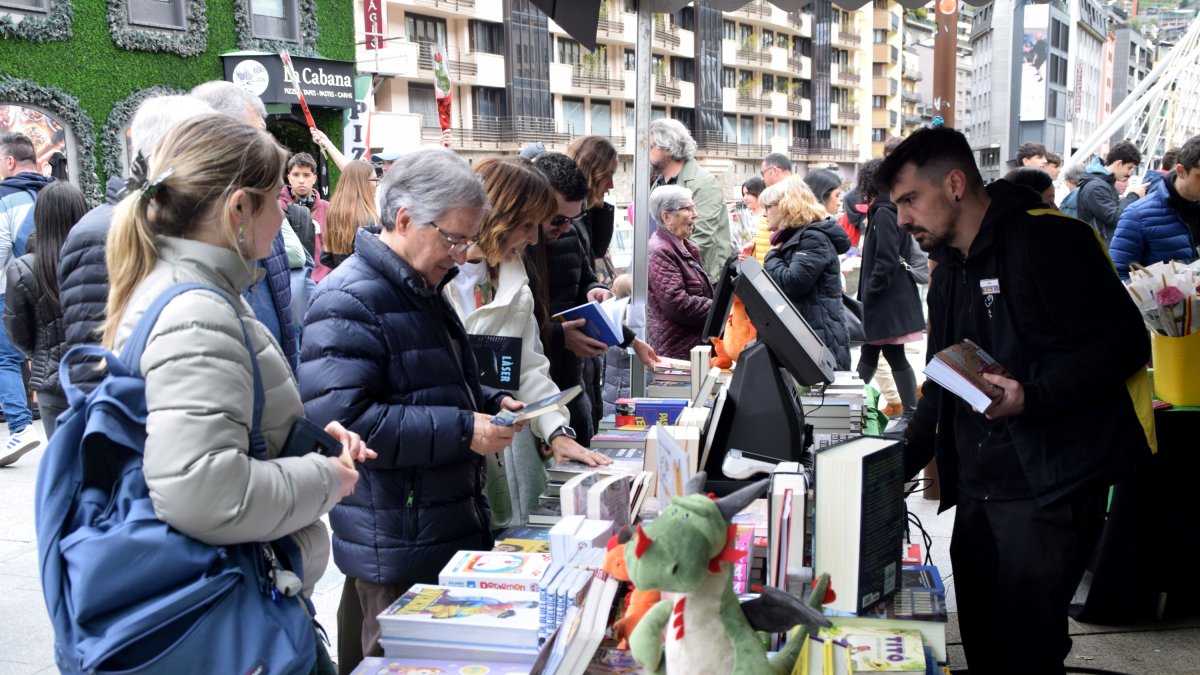 Un grup de persones comprant llibres en una parada d'Andorra la Vella.