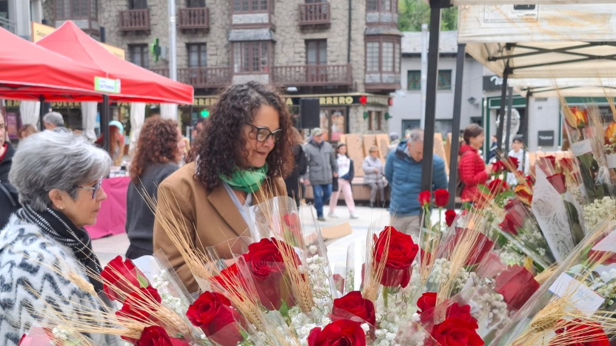 Dues clientes comprant roses en una parada de Sant Jordi.