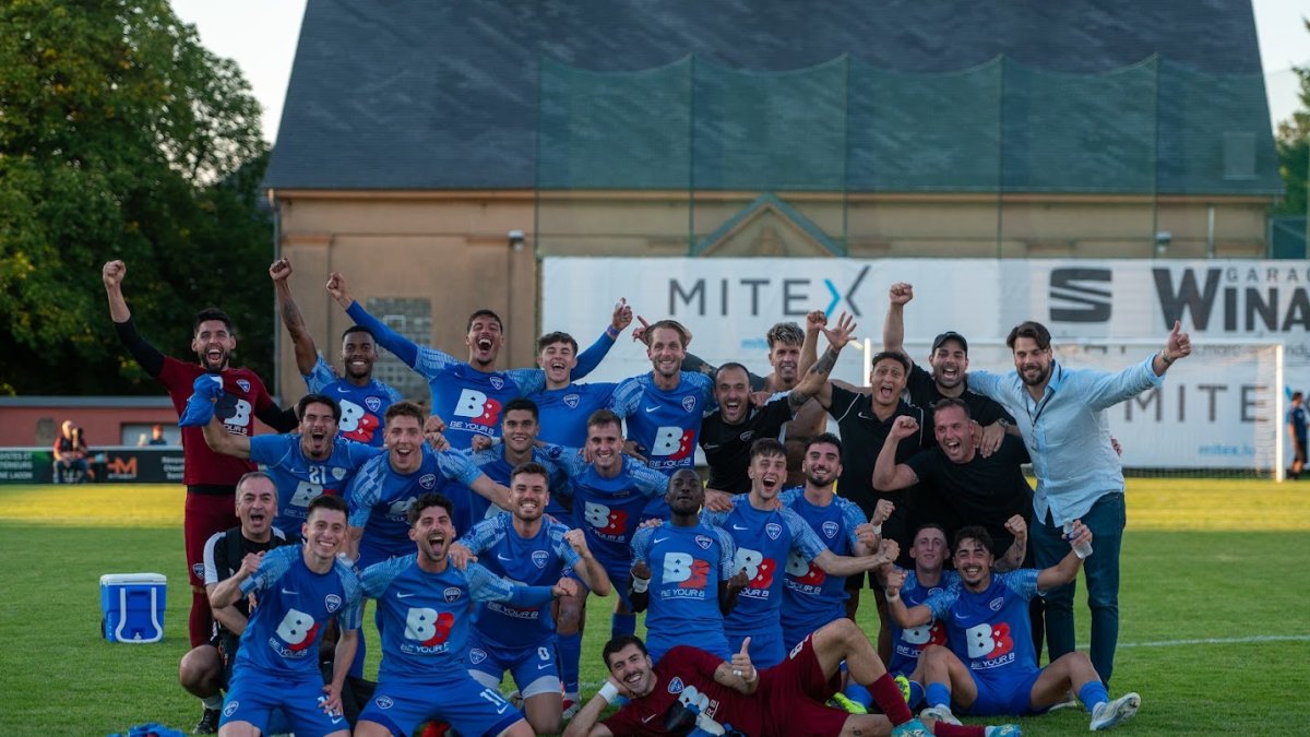 Els jugadors i l’staff tècnic de l’Atlètic Escaldes celebren la classificació al camp de l’F91 Dudelange.