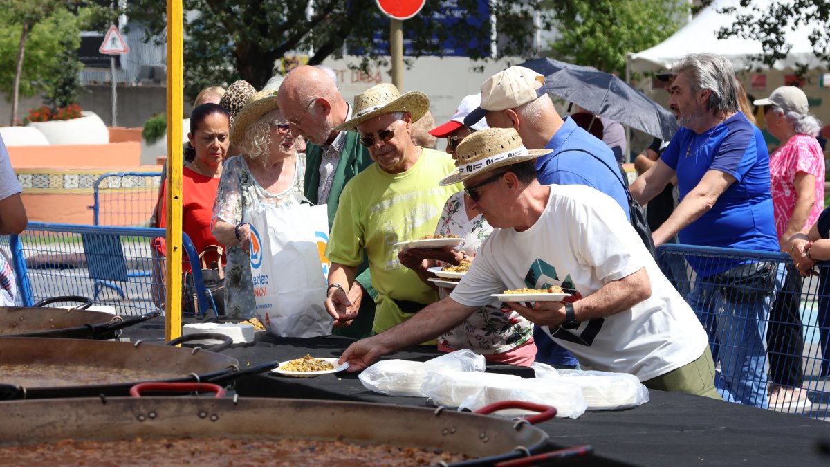 Un grup de persones agafant l’arròs.