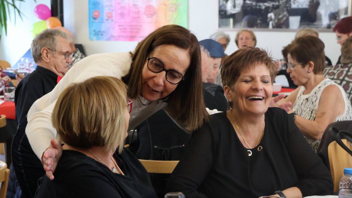 La consellera de Social, Eva Ramos, amb les persones assistents al dinar de celebració dels 10 anys de la llar de Lòria a l'edifici Glòria.