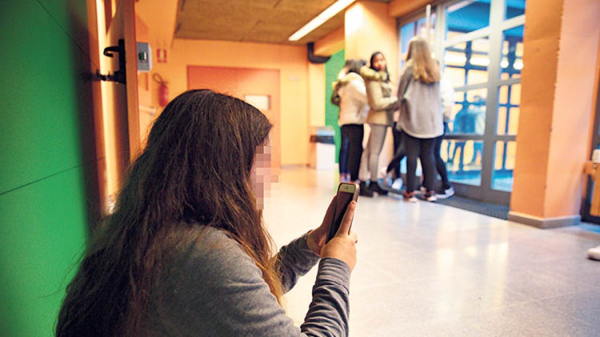 Una estudiant amb un telèfon mòbil.