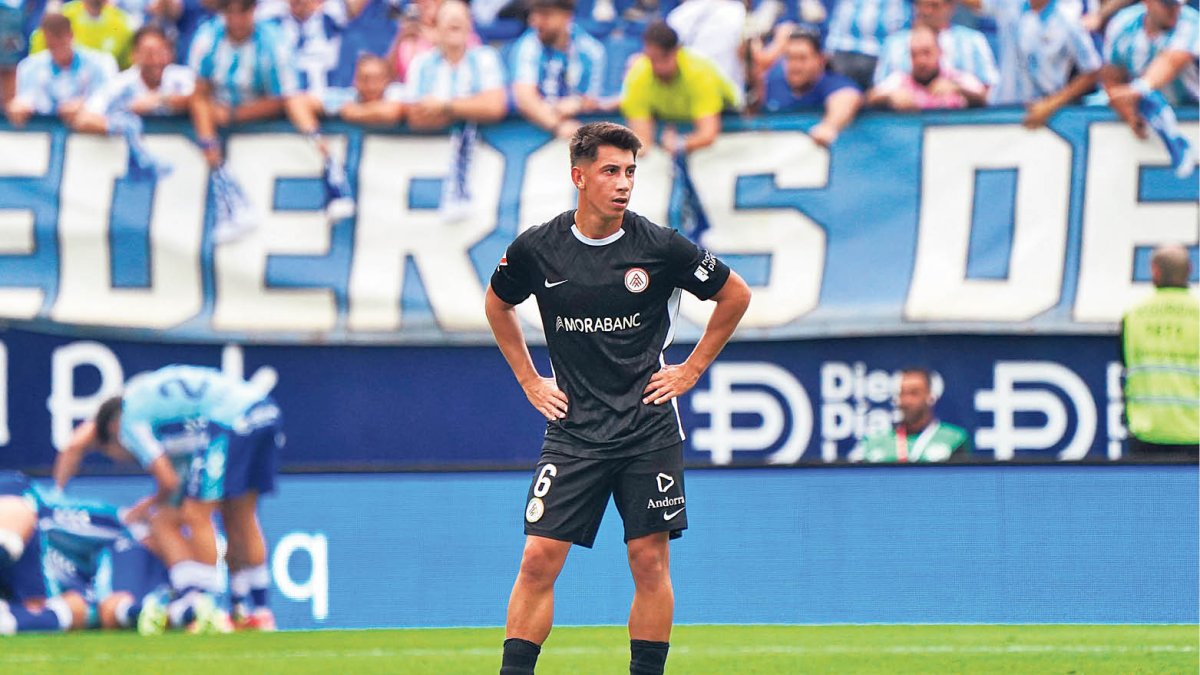Villahermosa, molt decebut, amb els jugadors del Màlaga celebrant al fons.