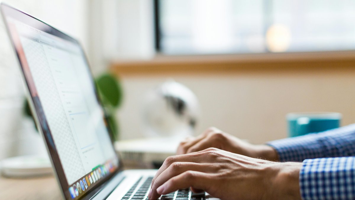 Una persona escrivint en un ordinador.