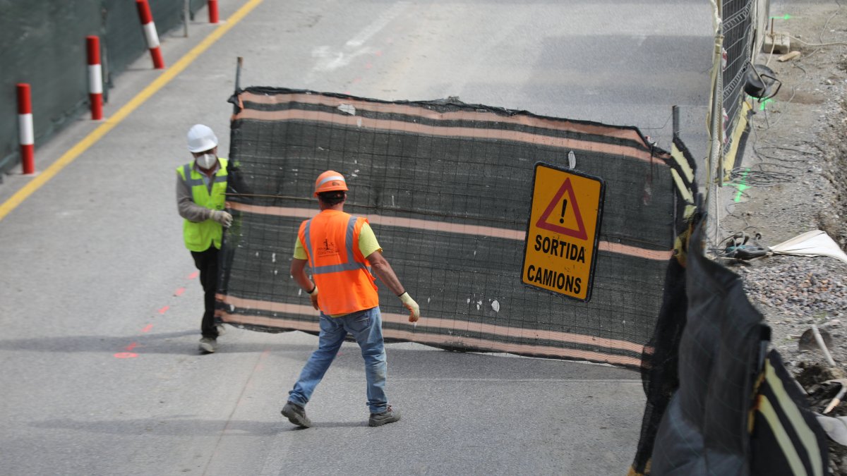 Uns treballadors obren el pas a l’accés a una obra.