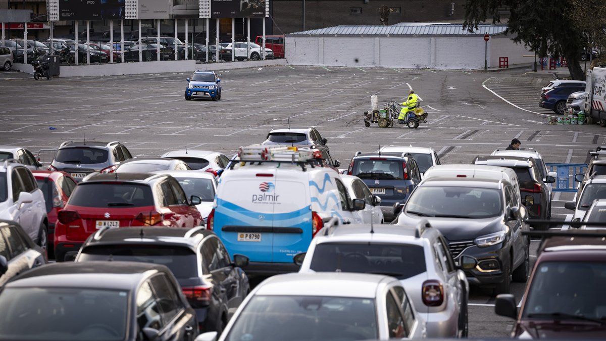 Un treballador pintant les noves places d'aparcament.