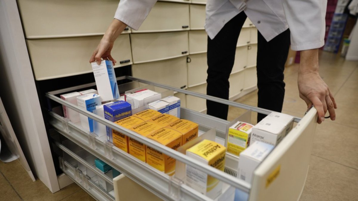 Una farmacèutica buscant un medicament.