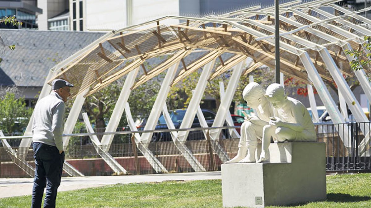 Estàtua al Parc Central que representa dos joves mirant el telèfon mòbil.