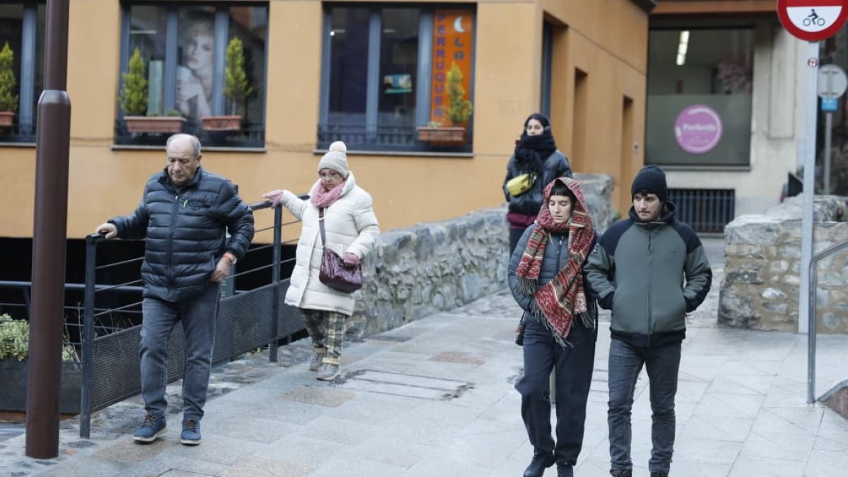 Diverses persones s'agafen a una barana per no caure, a Escaldes, aquest matí.