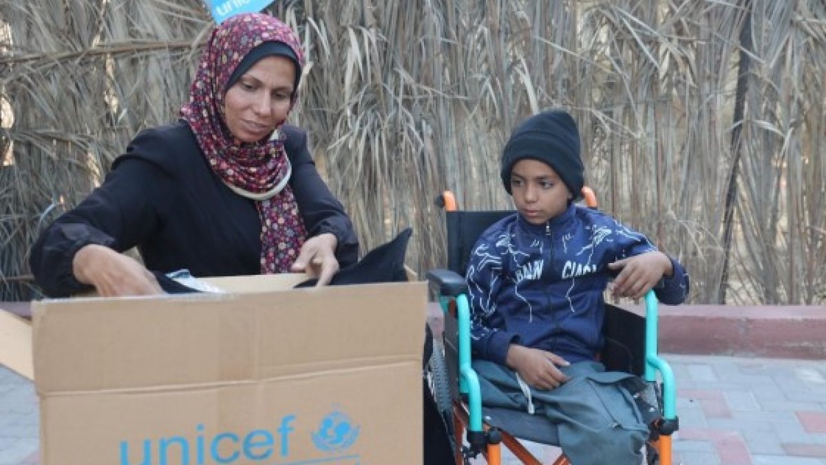 Una família de Gaza amb un paquet d'ajuda humanitària d'UNICEF.