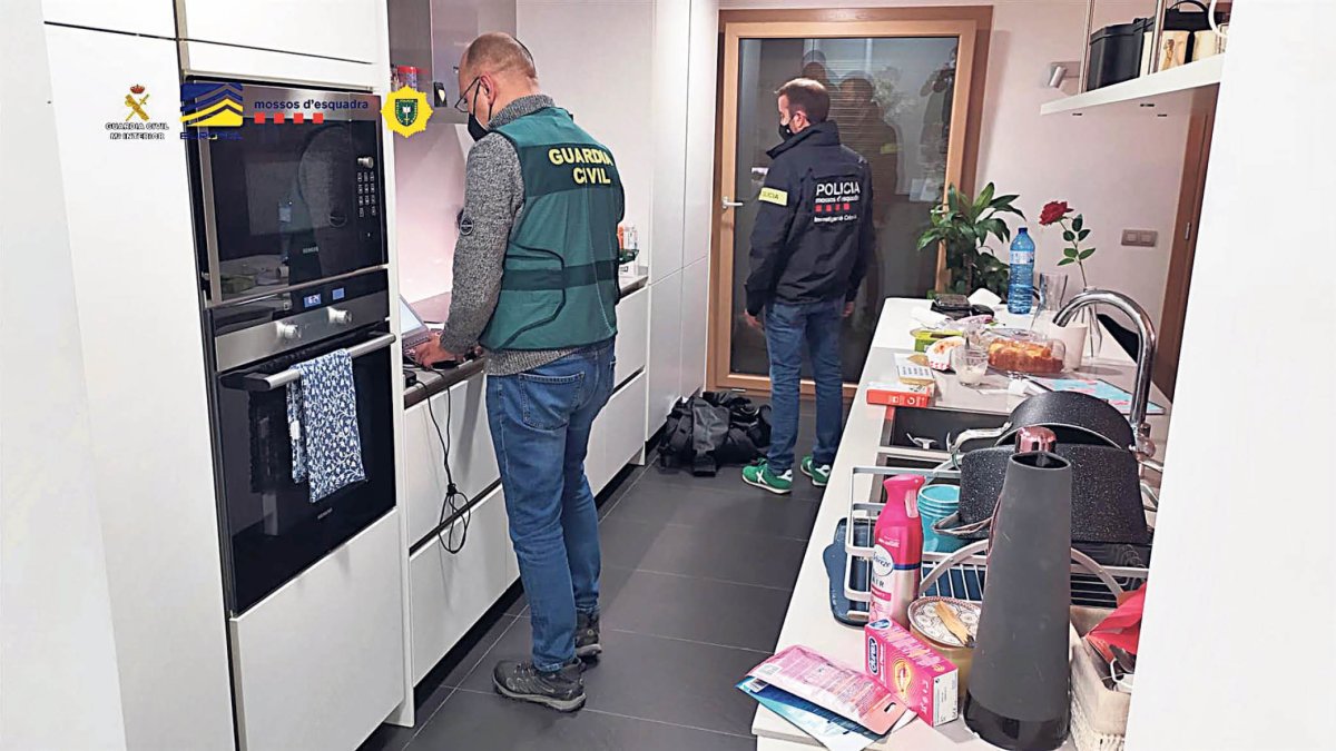 Un guàrdia civil i un mosso registren el domicili.